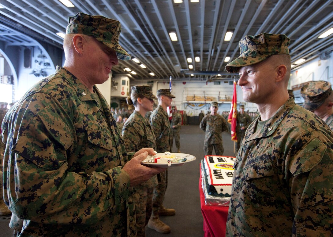 Right to left, U.S. Marine Corps Lt. Col. Chris S. Richie, commanding officer for Special-Purpose Marine Air-Ground Task Force Continuing Promise 2010, smiles as Lt. Col. Hubert A. Davis, executive officer for Marine Medium Helicopter Squadron 774, attached to Special-Purpose Marine Air-Ground Task Force CP10, eats the first piece of birthday cake during the Marine Corps 235th birthday celebration in the hangar bay of the amphibious assault ship USS Iwo Jima, Nov. 10, 2010. Service members and civilians are deployed in support of CP10 providing medical, dental, veterinary, engineering assistance and subject-matter exchanges to Caribbean, Central and South American nations. Service members and civilians are currently off the coast of Cuba.