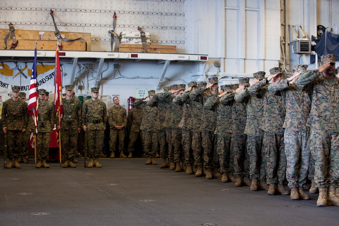 U.S. Marines with Special-Purpose Marine Air-Ground Task Force Continuing Promise 2010 salute during the Marine Corps 235th birthday celebration in the hangar bay of the amphibious assault ship USS Iwo Jima, Nov. 10, 2010. Service members and civilians are deployed in support of CP10 providing medical, dental, veterinary, engineering assistance and subject-matter exchanges to Caribbean, Central and South American nations. Service members and civilians are currently off the coast of Cuba.