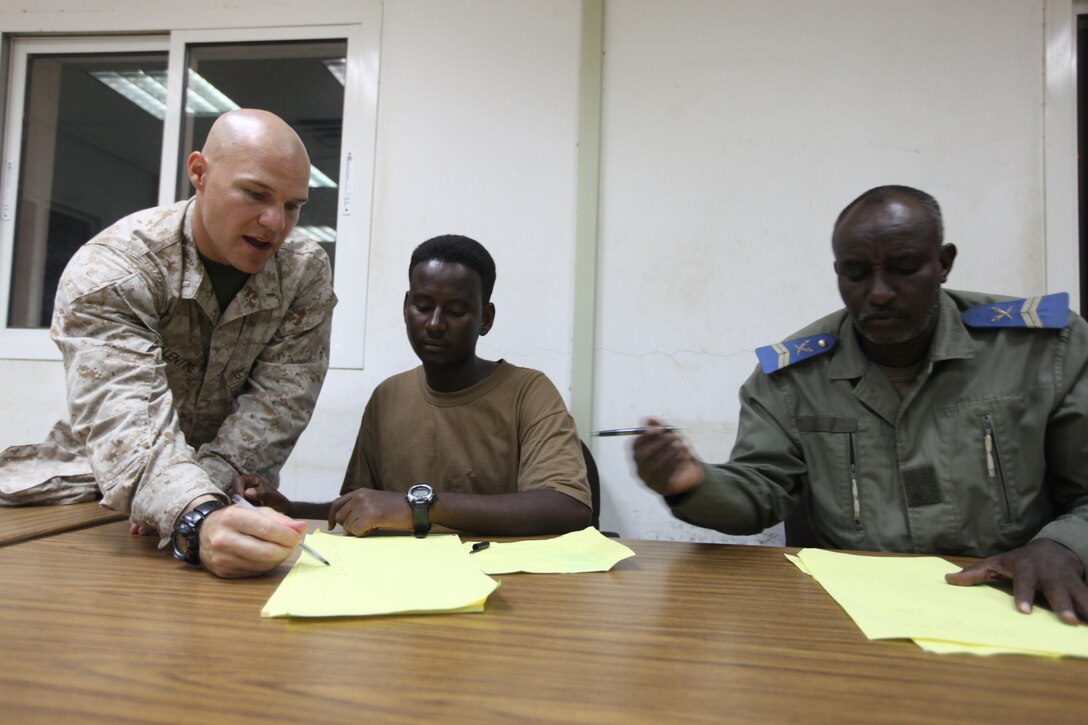 1st Lieutenant Jason Balentine, mortar platoon commander for Fox Battery 2/12, 26th Marine Expeditionary Unit, assists a local guard in copying vocabulary words during an English as a Second Language Class held aboard Camp Lemonnier, Djibouti, Africa, Nov. 10, 2010. Elements of 26th Marine Expeditionary Unit conducted sustainment training for their current deployment at Camp Lemonnier, Djibouti, and surrounding areas