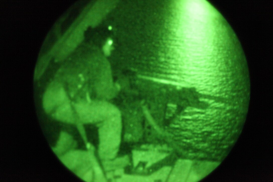 Staff Sgt. Chris S. Garrison, a CH-53E crew chief with Marine Heavy Helicopter Squadron 366, fires a .50-caliber belt-fed machine gun out the rear of a CH-53E Super Stallion during a night flight, Nov. 10. Garrison surpassed 3,000 hours of flight time on the mission, after 16 years in the Marine Corps.