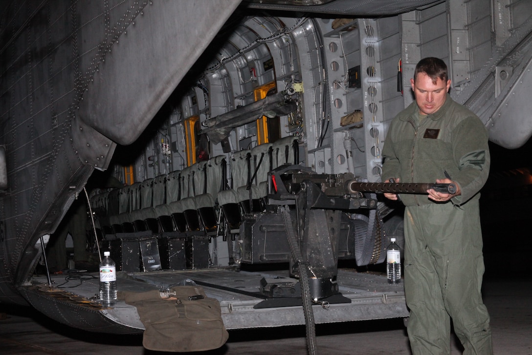 Staff Sgt. Chris S. Garrison, a CH-53E crew chief with Marine Heavy Helicopter Squadron 366, prepares the .50-caliber machine gun before a night shoot in flight on a CH-53E Super Stallion, Nov. 10.