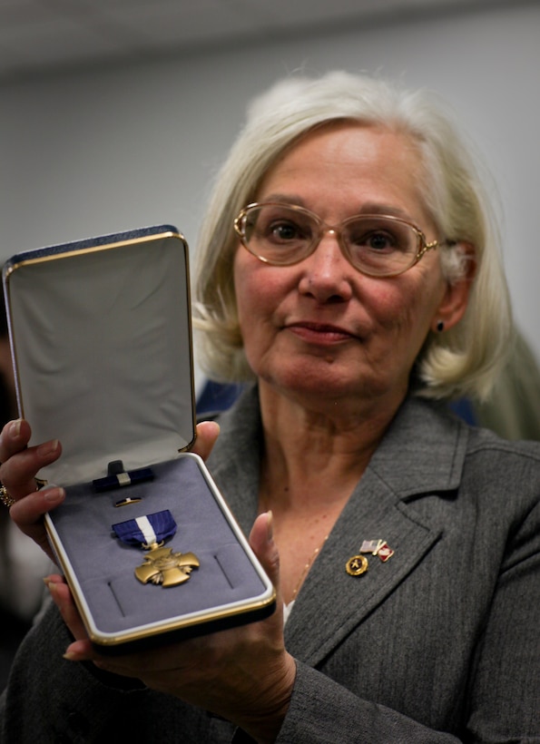 Secretary of the Navy Ray Mabus presented the Navy Cross to Donna Ouellette, mother of fallen Marine Cpl. Michael W. Ouellette, on behalf of her son in a ceremony in Manchester, N.H., Nov. 10, 2010. Ouellette was killed after an improvised explosive device detonated underneath him while he was patrolling in Helmand province, Afghanistan, March 22, 2009. Ouellette continued to lead his squad by directing fire from his riflemen and calling in the ambush over the radio. Moffett, received the radio transmission and described Ouellette’s actions as selfless and heroic. Ouellette succumbed to his wounds as he was evacuated from t the area, shortly after the radio transmission.