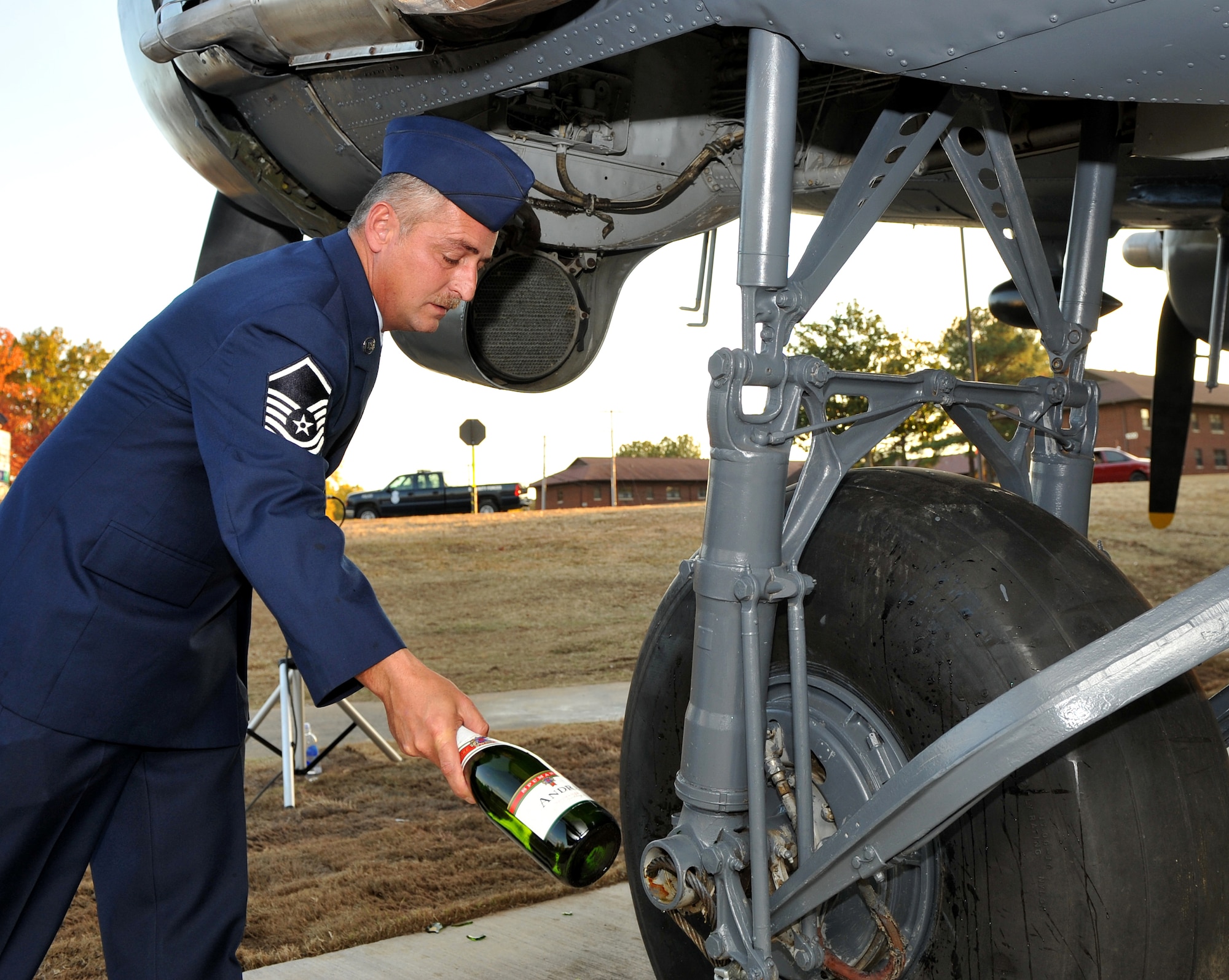 Master Sgt. James Walters, a 62nd Airlift Squadron flight engineer, broke a champagne bottle on the wheel of a C-47 static display Nov. 10 during the aircraft’s christening at the Veterans Day Retreat ceremony at Heritage Park. Team Little Rock Airmen worked for several months repairing and repainting the C-47 Skytrain to match its June 1944 D-Day paint scheme. (U.S. Air Force photo by Senior Airman Gul Crockett)