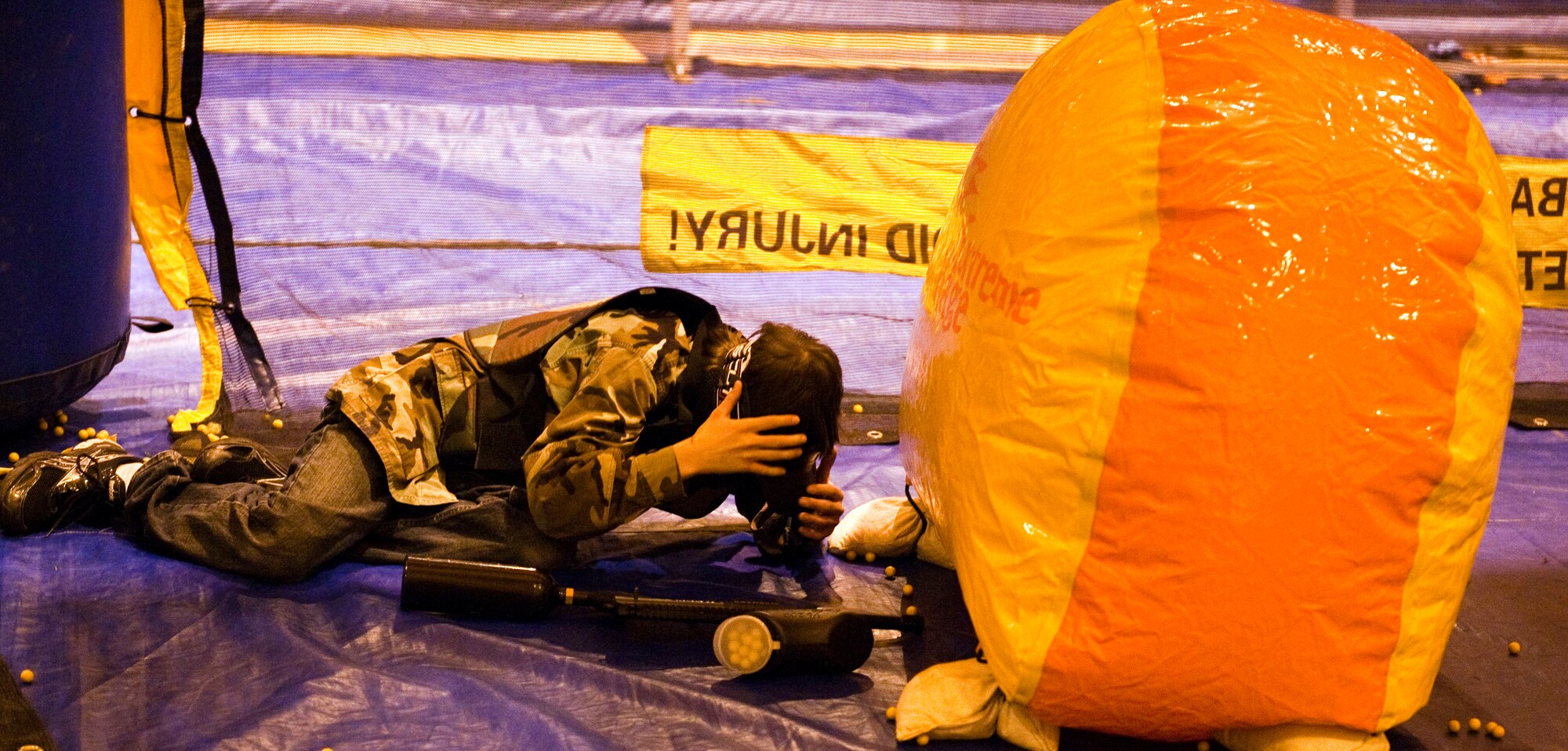 JOINT BASE ELMENDORF-RICHARDSON, Alaska, -- Bower Hall takes cover during a speed ball game with friends Nov. 6.  The Warrior Extreme Paintball course is bringing speed ball, a paintball like sport which uses softer ammunition that stays intact rather than paintballs, to the Buckner Gym on a trial basis. (U.S. Air Force photo/ Airman 1st Class Jack Sanders)