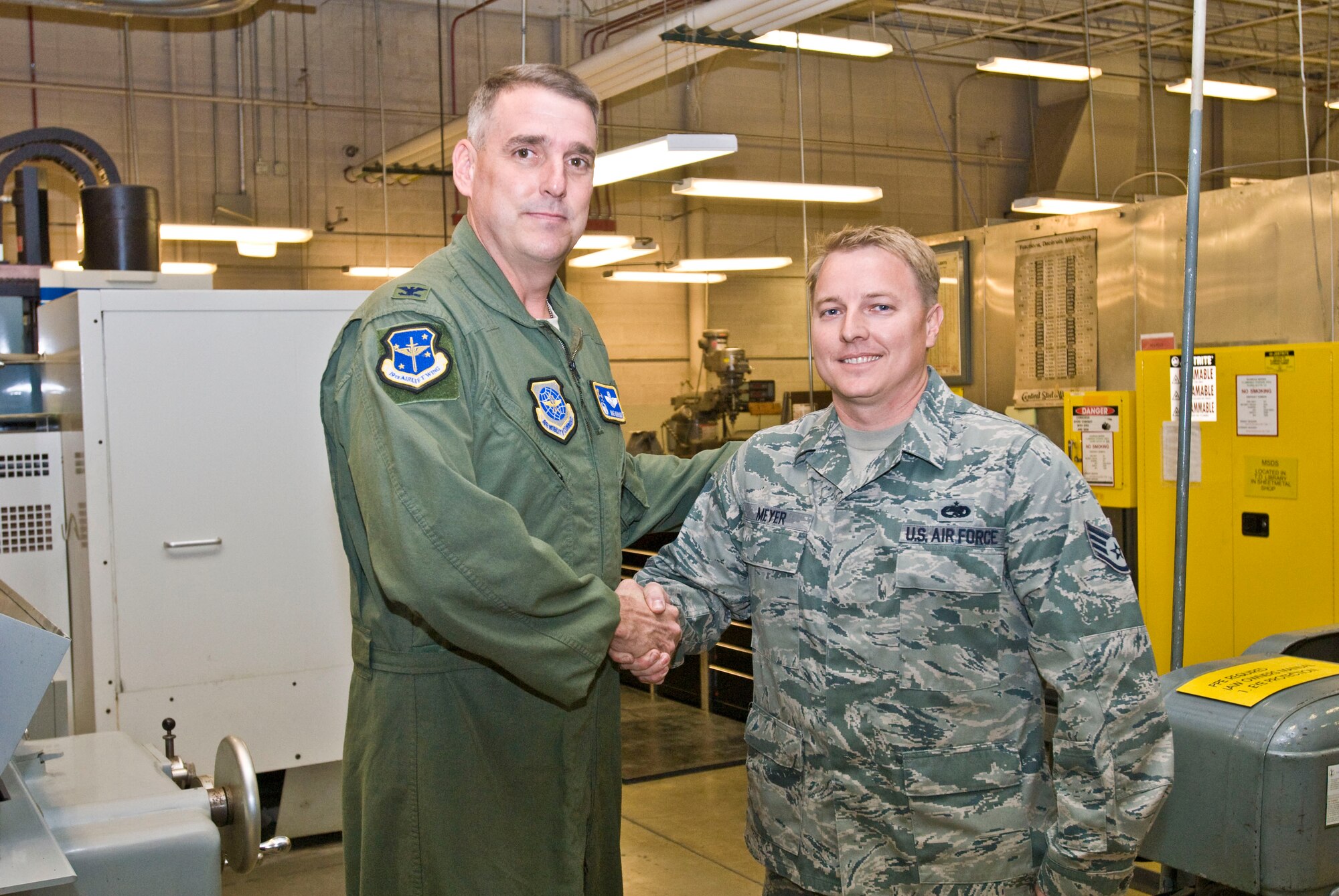 Col. Mike Minihan (left), 19th Airlift Wing commander, presents a coin Nov. 9 to Staff Sgt. Geoffrey Meyer, a 189th Maintenance Squadron aircraft metals technology craftsman, for his selection as the Combat Airlifter of the Week. As the unit diagnostic equipment monitor, Sergeant Meyer maintained 100-percent accountability on all 189th MXG test and measurement equipment. (U.S. Air Force photo by Staff Sgt. Nestor Cruz)