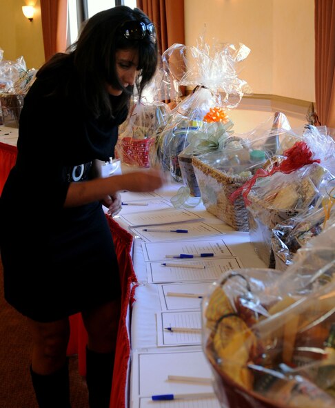 Judy O'Connor, Barksdale Officers Spouses' Club member, wife of Col. Michael O'Connor, Air Force Global Strike Command deputy staff judge advocate, looks over and bids on a variety of baskets donated by various members, guests and squadrons from Barksdale, Shreveport and Bossier City community during the BOSC silent auction luncheon held at the Barksdale Club on Barksdale Air Force Base, La., Nov. 10. There were more than 20 baskets available for bid. (U.S. Air Force photo/Senior Airman La'Shanette V. Garrett) (RELEASED)