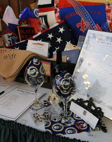 An "All Things Military Basket" donated by Eighth Air Force receives one of the highest bids during the Barksdale Officers Spouses' Club  silent auction luncheon held at the Barksdale Club on Barksdale Air Force Base, La., Nov. 10. The basket consisted of books, a military T-shirt quilt, Eighth Air Force commander's coin, U.S. flag and an authentic ammo box just to name a few. The auction raised more than $2,100, which will be used to fund the Hap House holiday party. The Hap House is a non-profit organization on Barksdale that provides mentally and physically disabled adults the opportunity to earn a pay check. (U.S. Air Force photo/Senior Airman La'Shanette V. Garrett)(RELEASED)