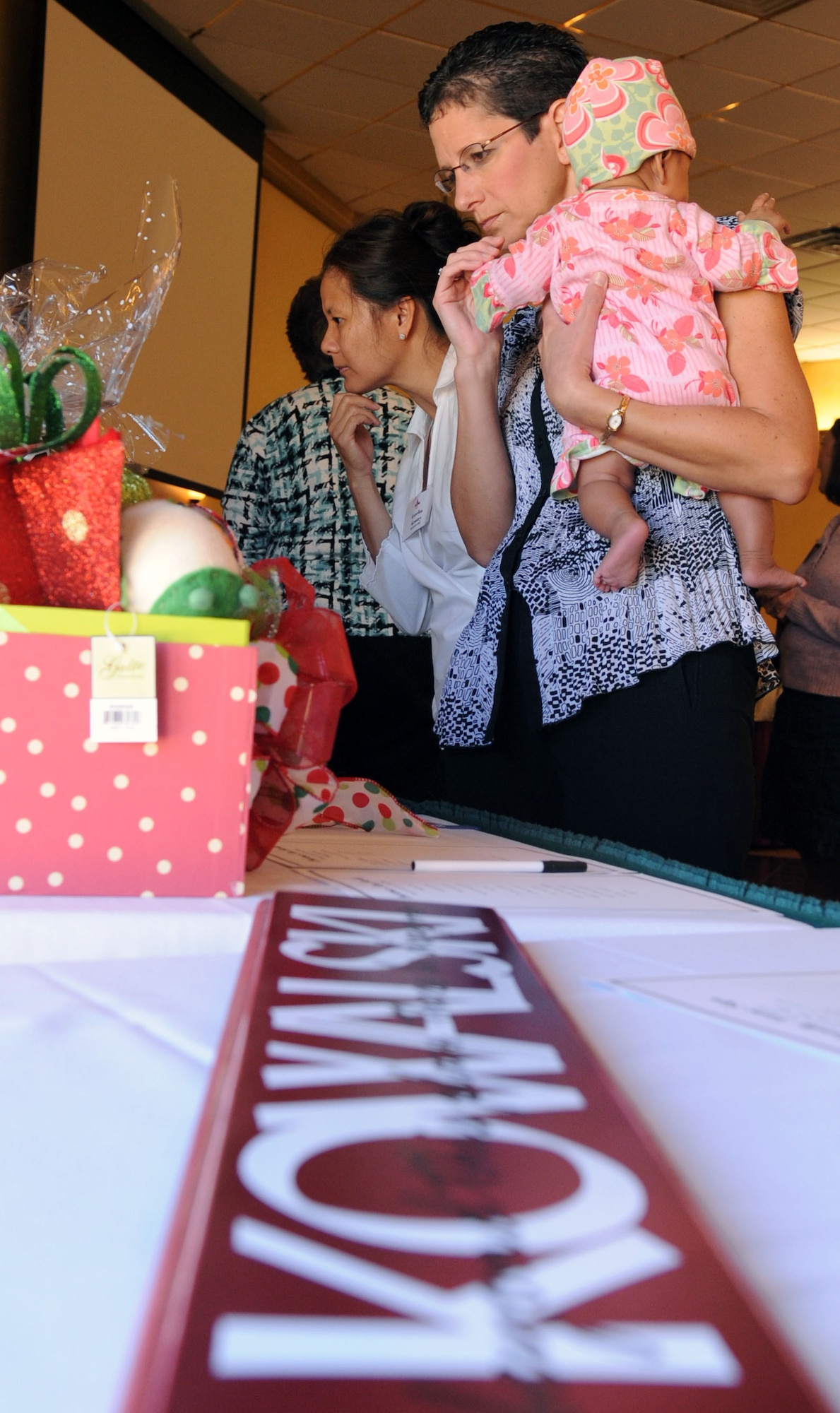 Connie Menard, Barksdale Officers Spouses' Club member, wife of Col. Robert Menard, Air Force Global Strike chief of contracting division, observes a variety of baskets during the BOSC silent auction luncheon held at the Barksdale Club on Barksdale Air Force Base, La., Nov. 10. The proceeds from the auction will help fund The Hap House holiday party. The Hap House is a non-profit organization on Barksdale that provides mentally and physically disabled adults the opportunity to earn a pay check. (U.S. Air Force photo/Senior Airman La'Shanette V. Garrett)(RELEASED)