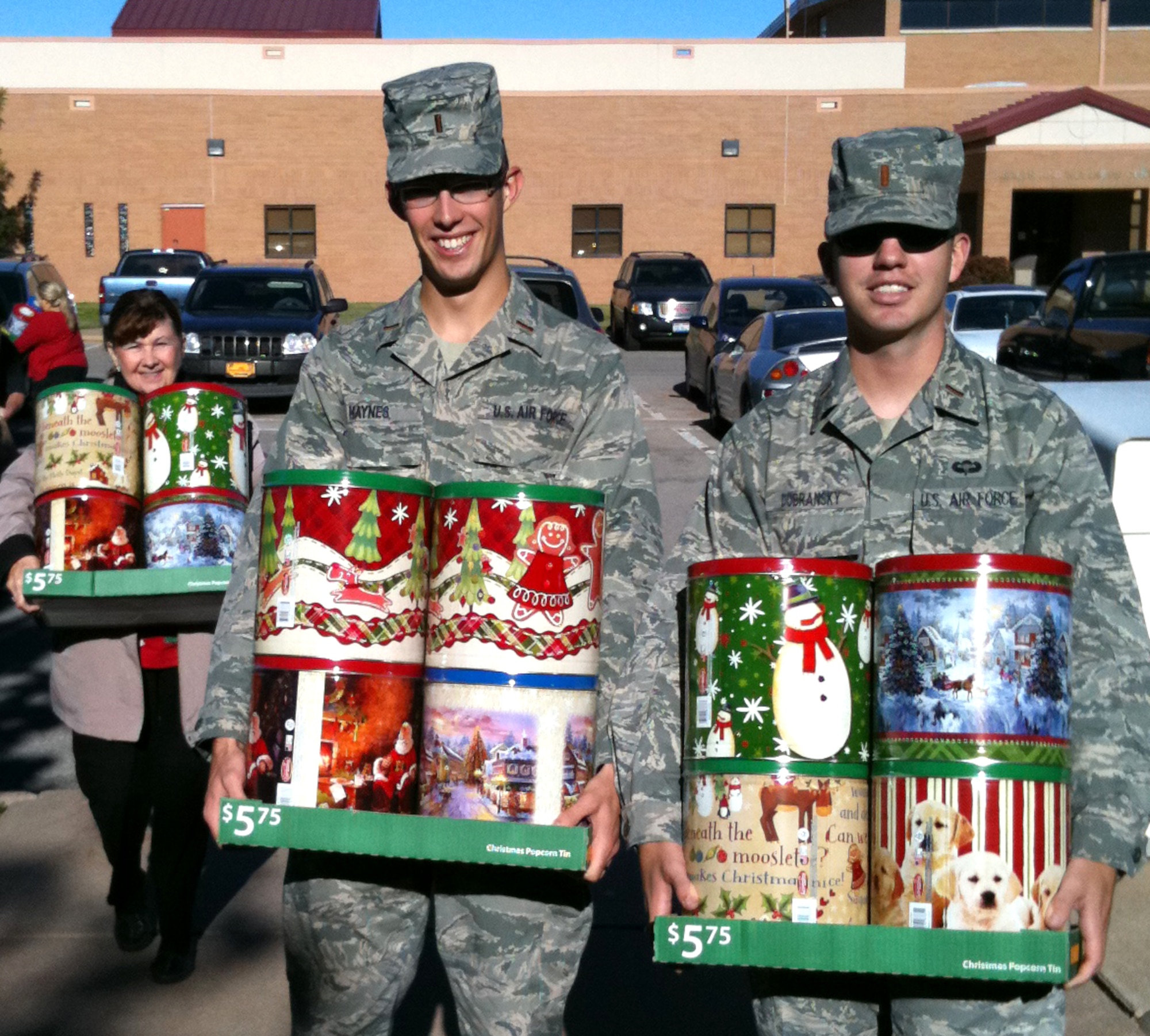 Bringing tins of popcorn to pack in holiday care-packages for Vance’s deployed Airmen are, back left, Terri Presa, center, 2nd Lt. Dustin Haynes and 2nd Lt. Mike Dobransky. Fifty-five boxes of cookies, candy, popcorn, stuffed animals and cards and letters were packed and mailed by 30 volunteers at the Vance AFB Airman & Family Readiness Center, Nov. 4. (U.S. Air Force photo/ Lynne Mack)
