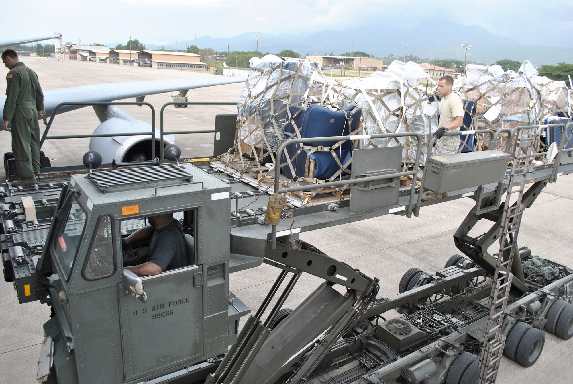 Airmen from the 2nd Air Refueling Squadron out of Joint Base McGuire-Dix-Lakehurst, N.J., the 612th Air Base Squadron Air Terminal Operations Center work together to unload eight pallets of humanitarian supplies Oct. 25, 2010, at Soto Cano Air Base, Honduras. The supplies were brought to Soto Cano Air Base, Honduras, through the Denton Program, which allows the Department of Defense to use extra space on U.S. military cargo aircraft to transport humanitarian assistance materials. (U.S. Air Force photo/Staff Sgt. Andre De La Torre)
