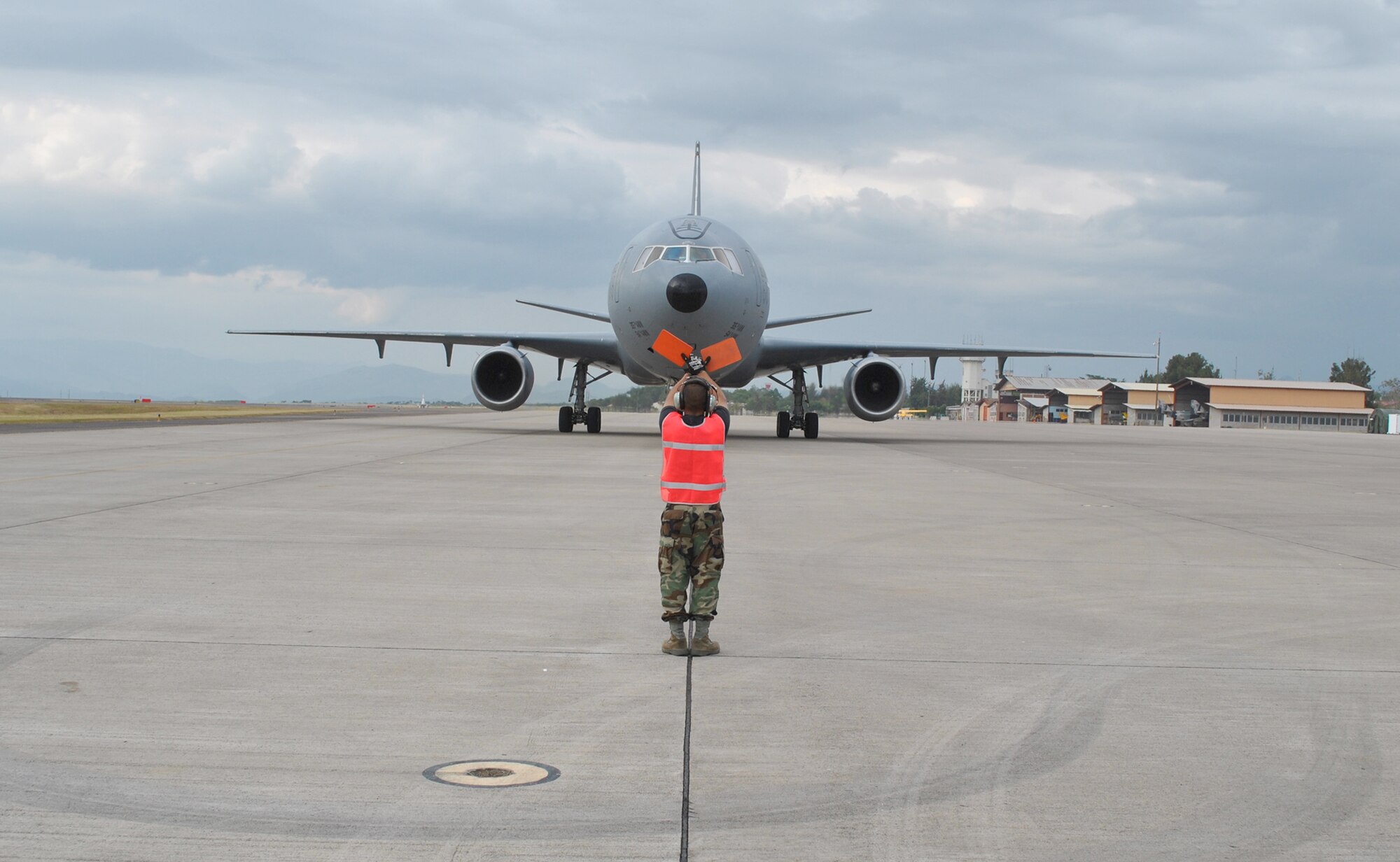 An Airman from the 612th Air Base Squadron Air Terminal Operations Center guides in a KC-10 Extender from Joint Base McGuire-Dix-Lakehurst, N.J., Oct. 25, 2010, at Soto Cano Air Base, Honduras. The aircraft delivered 18 tons of humanitarian supplies bound for local charities. (U.S. Air Force photo/Staff Sgt. Andre De La Torre)
