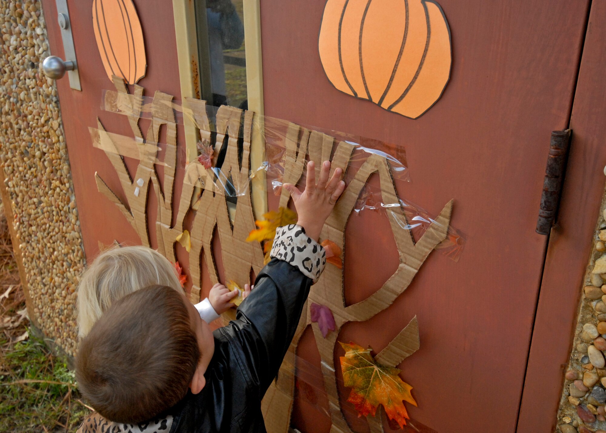 Children place leaves on the fall tree at the Child Development Center Fall Festival Nov. 10. The annual festival celebrated the Month of Military Families. (U.S. Air Force photo/Sachel Seabrook)
