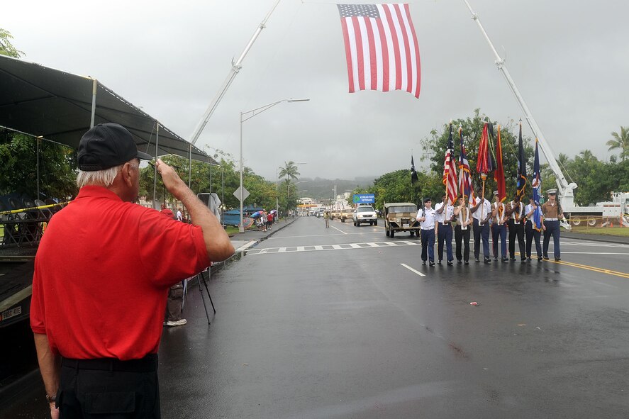 Dan Kama, event organizer, salutes the American flag as the National Security Agency/Central Security Service Joint Service Color Guard marches past the review stand during the 2010 Big Island Veterans Day Parade in Hilo, Hawaii, Nov. 6, 2010. City officials invited the National Security Agency/Central Security Service Joint Service Color Guard and the Naval Pacific Fleet Band to participate in the parade that day. (U.S. Air Force photo/Tech. Sgt. Jerome S. Tayborn)
