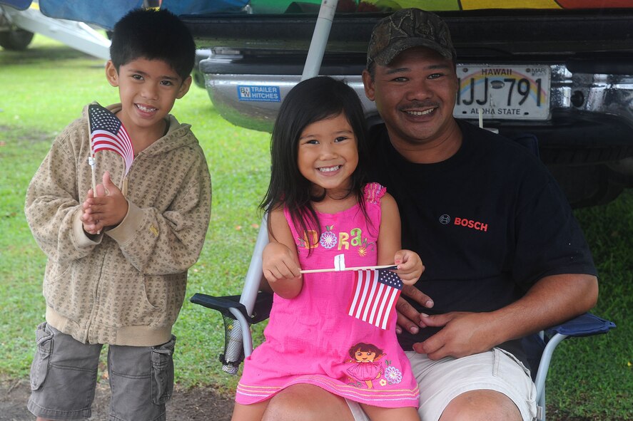 A father and his two small children proudly wave their American flags in support of the 2010 Big Island Veterans Day Parade in Hilo, Hawaii, Nov. 6. 2010. (U.S. Air Force photo/Tech. Sgt. Jerome S. Tayborn)