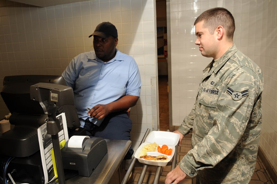 Kevin Harris, 2nd Force Support Squadron, rings up Airman 1st Class Shaun Evans, 2nd Operational Support Squadron, at the Red River Dining Facility on Barksdale Air Force Base, La., Nov. 10. The dining facility recently brought back its carry out option for Airmen on meal cards. (U.S. Air Force photo/Airman 1st Class Sean Martin)(Released)