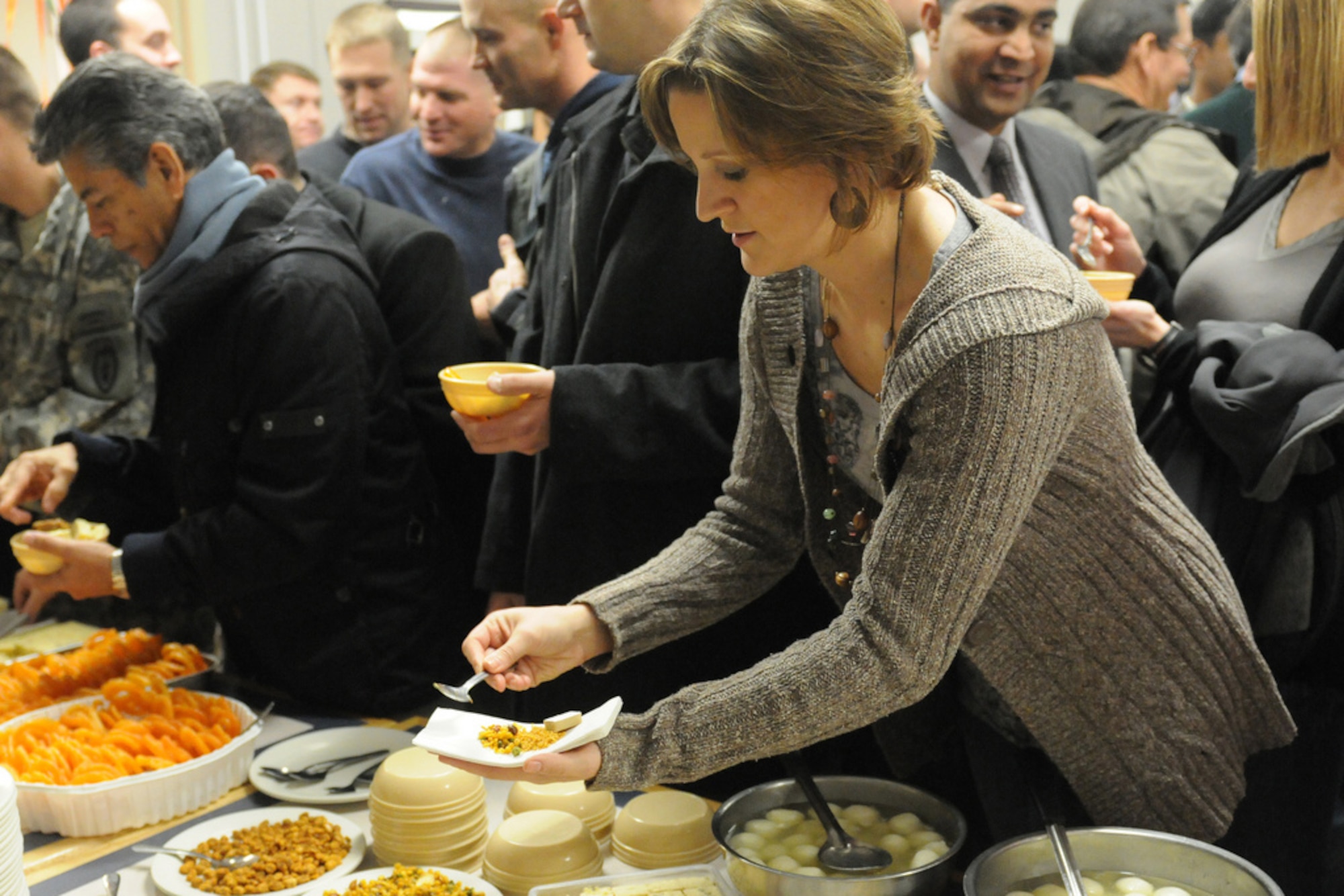 Sgt. Lindsay Ebert, 79th Special Troops Battalion (California Army National Guard) takes some Indian food during a Diwali festival celebrated Nov. 5 with soldiers from the Indian Army and U.S. Army Alaska at the Wilderness Inn dining facility on Joint Base Elmendorf-Richardson. (U.S. Army photoSpc. Ashley Armstrong)