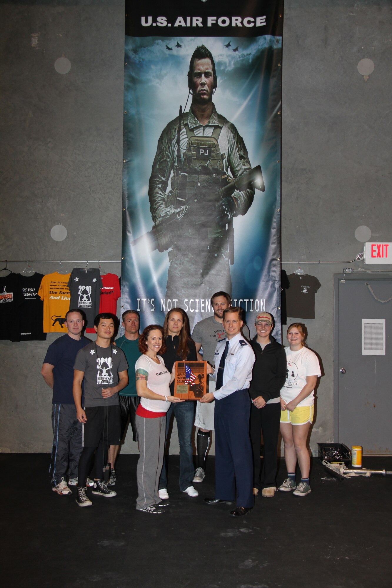 ST. LOUIS -- Lt. Col. Christopher Byrom, 345th RCS commander, presents Rochelle Thayer, owner of CrossFit TNT, the Air Force Salutes Award.  The award was presented  to CrossFit TNT for its support of the 345th RCS at Scott and the Air Force Recruiting Service. (Courtesy photo)