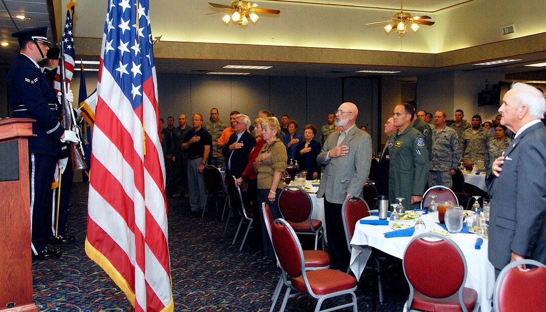 Guests at Sheppard's Veteran's Day Luncheon pay tribute to the nation's flag Nov. 9 at the Sheppard Club while the 77th Army Band from Fort Sill, Okla., plays the national anthem. Sheppard honored all veterans, past and present, during the event. (U.S. Air Force photo/Mike Litteken)