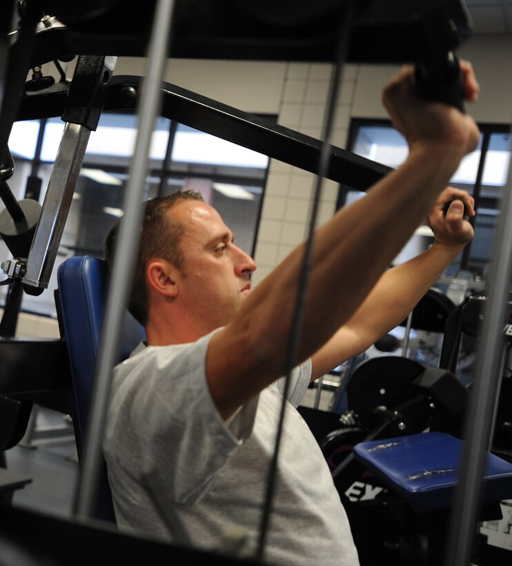 Staff Sgt. John Brennan lifts weights Nov. 9, 2010, at the base fitness center at McConnell Air Force Base, Kan. Sergeant Brennan is the 22nd Aircraft Maintenance Squadron crew chief. He scored a 69.4 on his initial physical training test, and after working out for 90 days, he retested and scored 93.7. (U.S. Air Force photo/Airman 1st Class Armando A. Schwier-Morales)