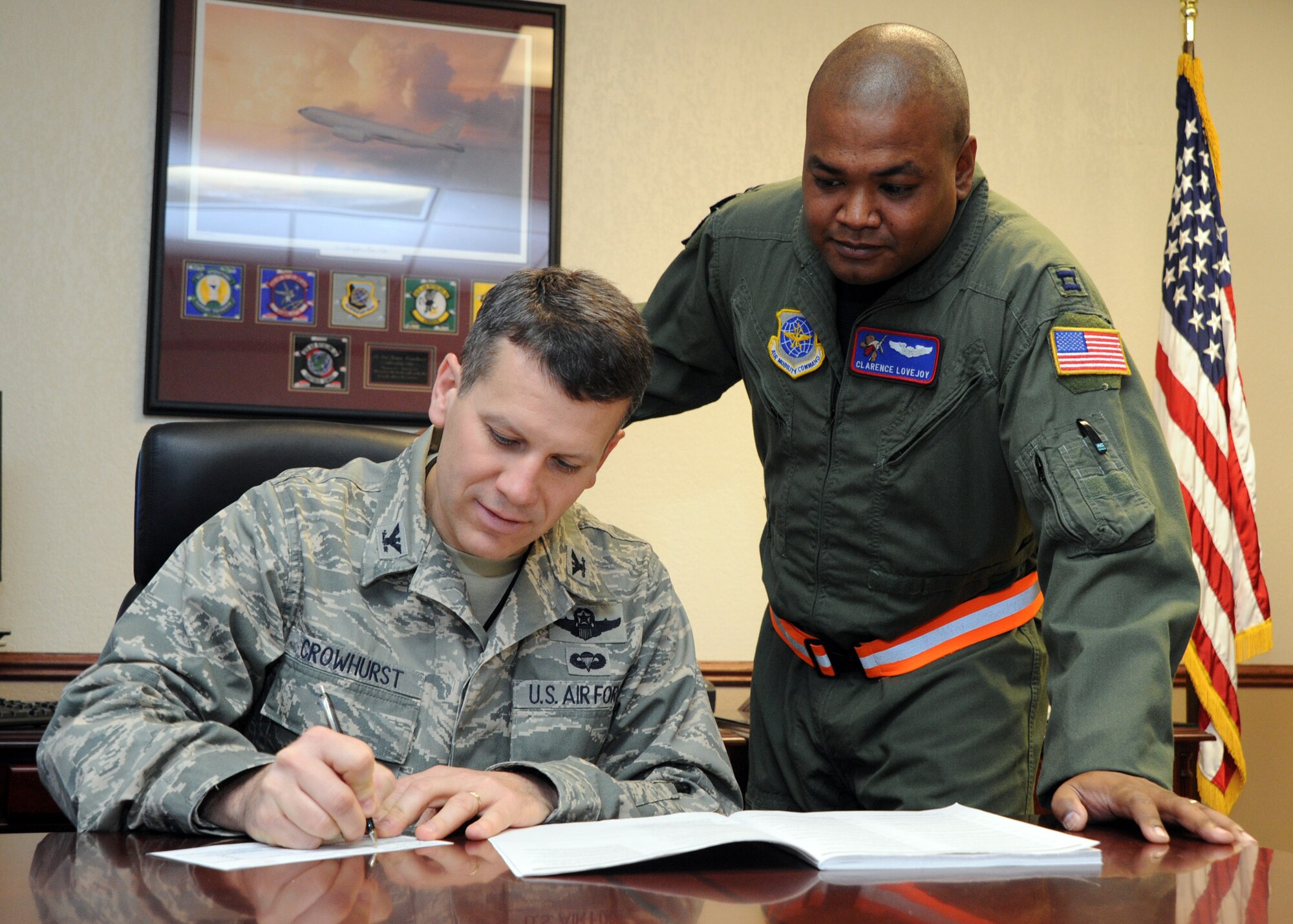 Col. Jamie Crowhurst, 22nd Air Refueling Wing commander, signs his Combined Federal Campaign pledge card with Capt. Clarence Lovejoy, 349th Air Refueling Squadron chief of standards and evaluations, and the 22nd Air Refueling Wing’s CFC point of contact.  The annual campaign will run through Dec. 10.  McConnell’s CFC representatives are hoping to exceed the base’s goal of $110,000.  (U.S. Air Force photo/Staff Sgt. Dallas Edwards)