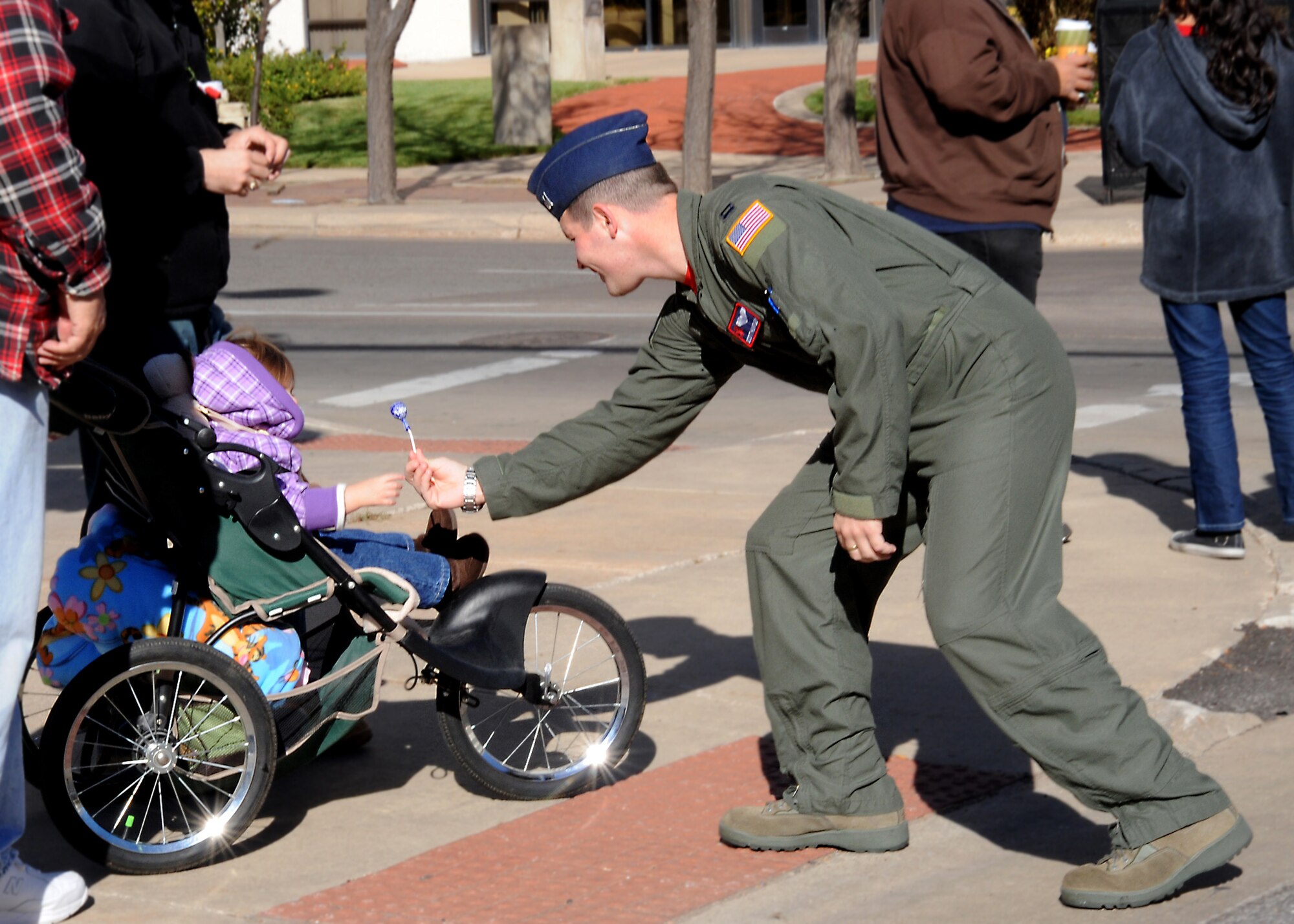 Capt. Scott Huntley, 350th Air Refueling Squadron executive officer, gives candy to a child watching Wichita’s annual Veterans Day parade Nov. 6, 2010, Wichita, Kan. Young and old spectators stood on the sidewalk to show their support for active duty military and veterans. (U.S. Air Force photo/Airman 1st Class Katrina M. Brisbin)