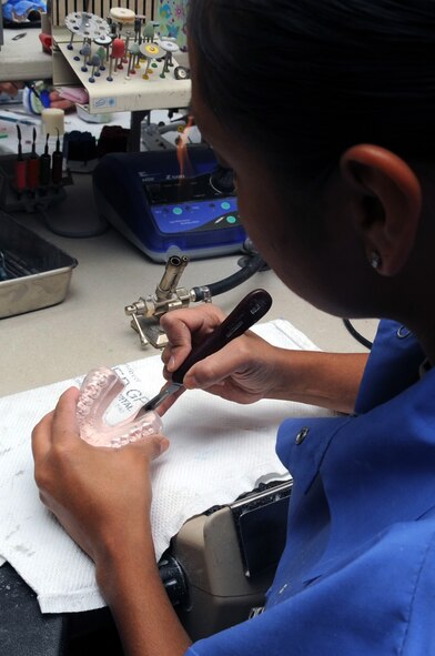 Staff Sgt. Felicia Chapko, 2nd Dental Squadron,  laboratory technician slices the sports guard from a patients diagnostic cast at Barksdale Air Force Base, La., Nov. 9. The cast will be used to mold an athletic mouth guard. The dental clinic offers both general dentistry and special dental treatment for active-duty and family members (U.S. Air Force photo/Senior Airman Brittany Y. Bateman)(RELEASED)