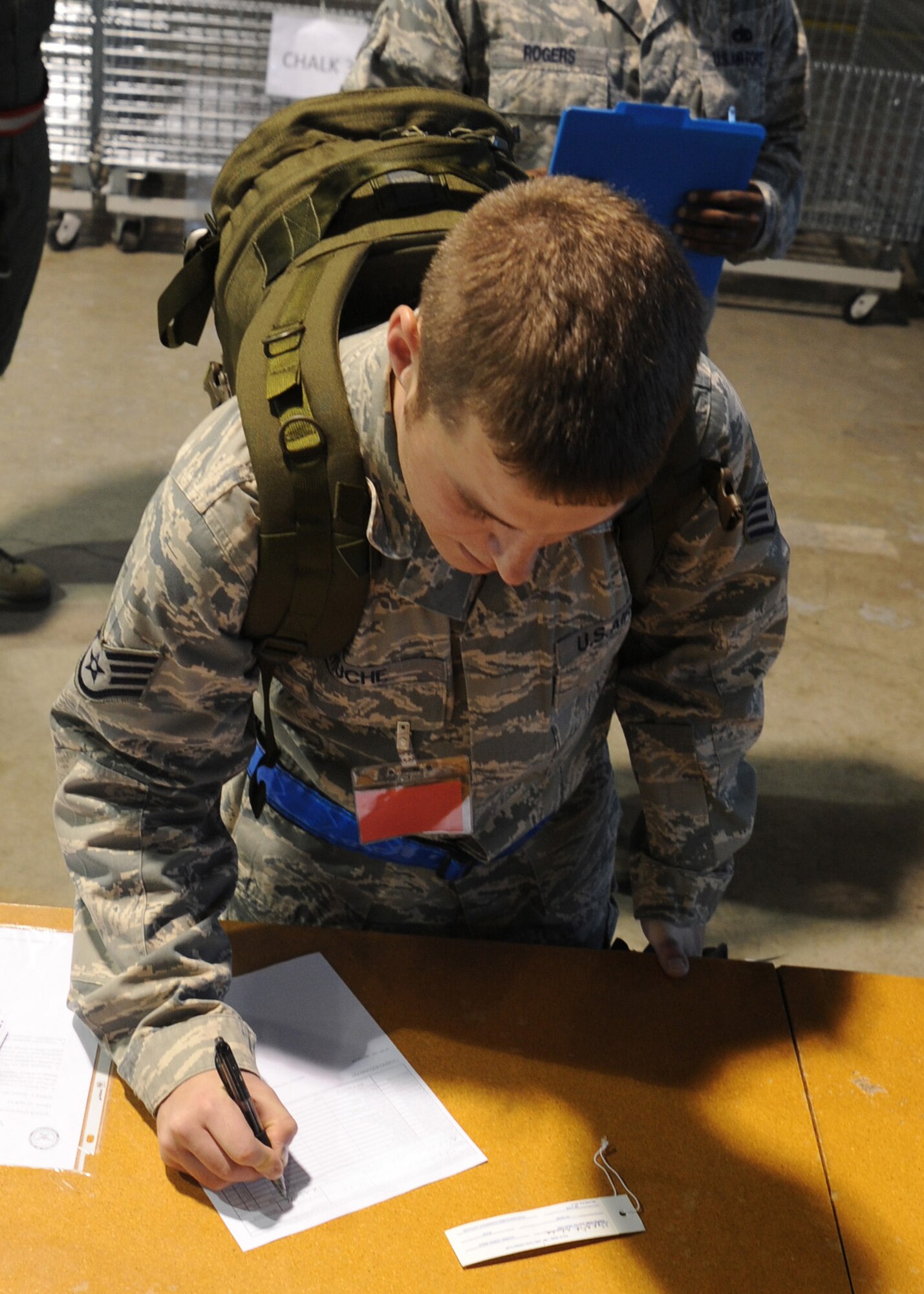Staff Sgt. Nicholas Muche, 22nd Contracting Squadron contingency contracting officer, signs for issued deployment gear during a readiness exercise Nov. 7, 2010, McConnell Air Force Base, Kan. Sergeant Muche and other McConnell Airmen sign for accountability for issued gear so supply personnel can keep track of all the equipment.  (U.S. Air Force photo/Staff Sgt. Dallas Edwards)