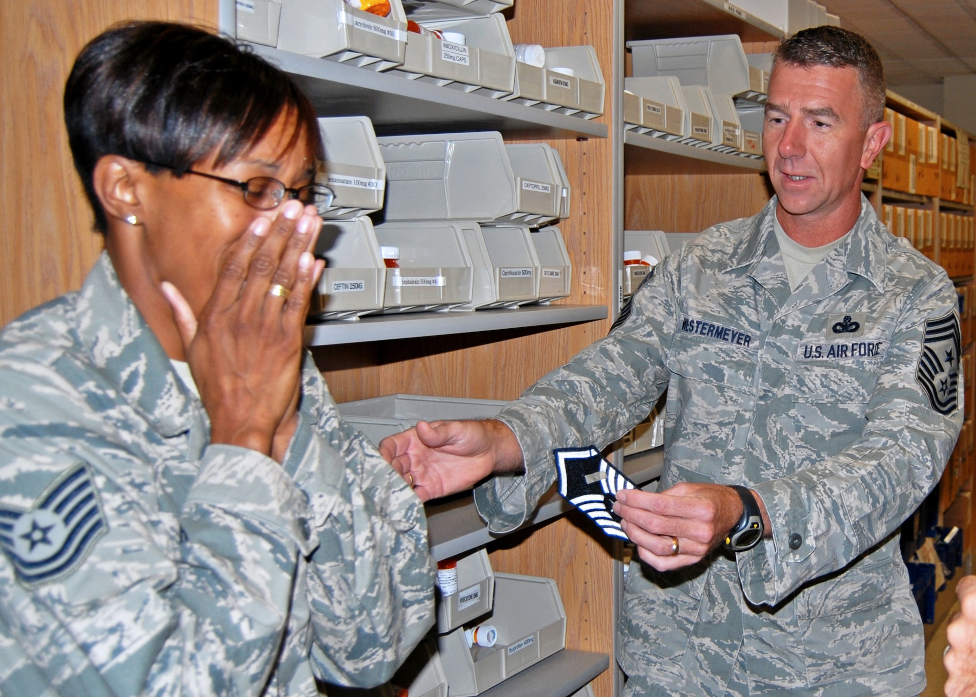 Newly promoted Master Sgt. Regina Brown, 96th Medical Group, reacts to the new stripes by Chief Master Sgt. Tom Westermeyer, 96th Air Base Wing command chief.  She along with three others from Eglin units were promoted under the Stripes for Exceptional Performers program.  (Courtesy photo)