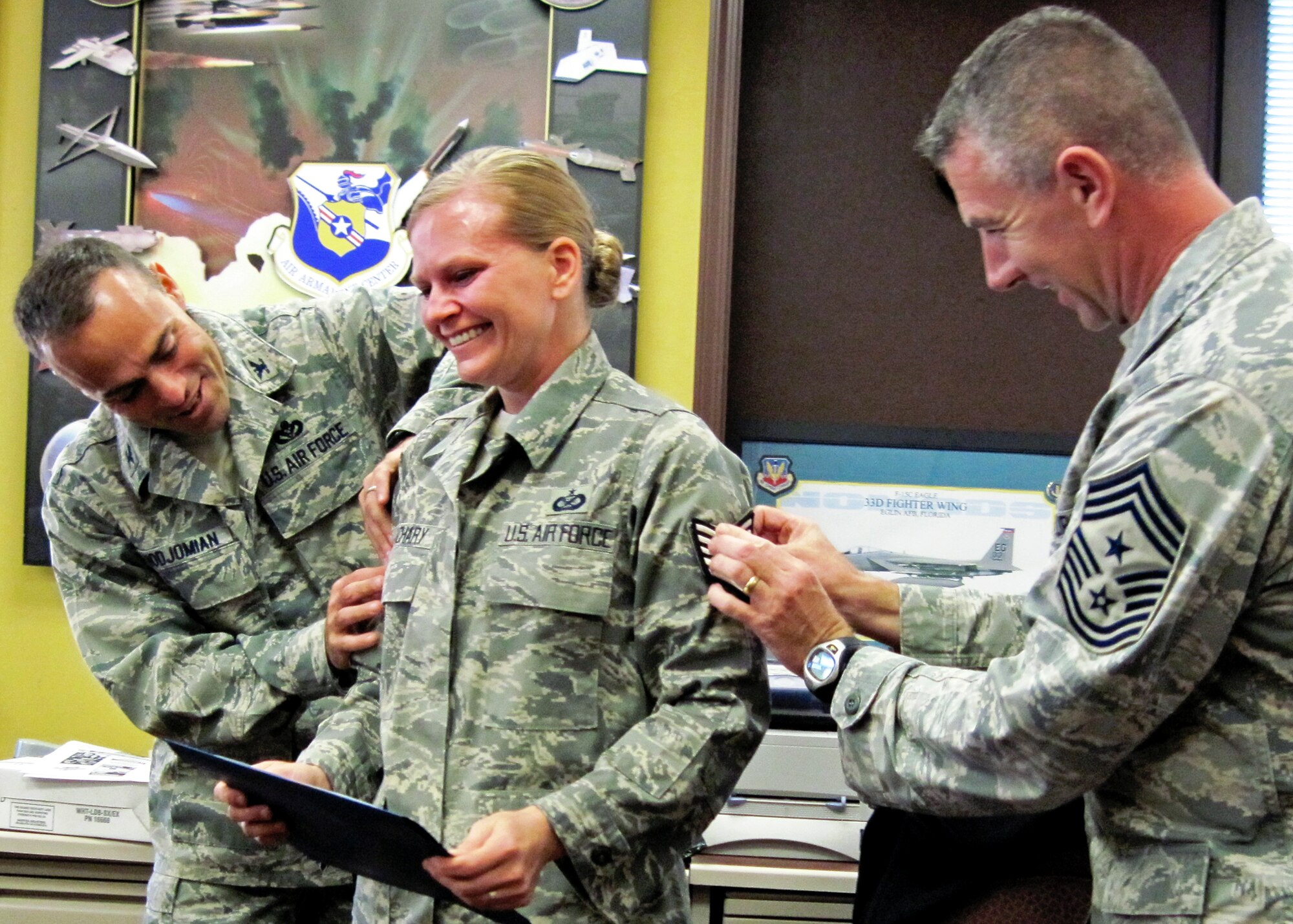 Newly promoted Tech. Sgt. Stacia Zachary, Team Eglin Public Affairs, receives her stripes from Col. Sal Nodjomian, 96th Air Base Wing commander, and Chief Master Sgt. Tom Westermeyer, 96th command chief Nov. 9.  She along with three others from Eglin units were promoted under the Stripes for Exceptional Performers program.  (U.S. Air Force photo/Chrissy Cuttita)