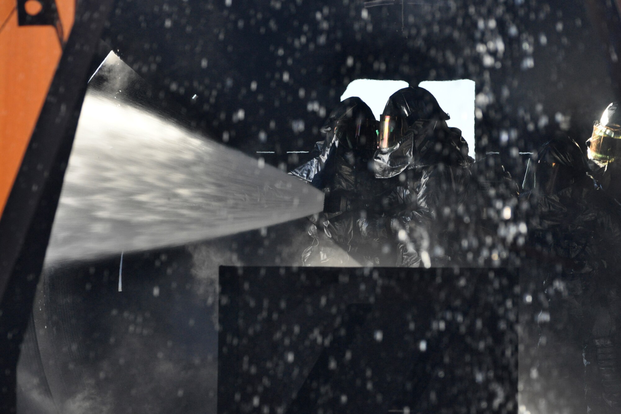 Col. John J. Mooney III, commander, 917th Wing, knocks down the remaining flames in what was once a burning aircraft trainer at Barksdale Air Force Base, La., Nov. 5, 2010. Colonel Mooney joined approximately 20 members of the 917th Civil Engineer Squadron Fire Department during wartime training, which included the extinguishing of a fire on a large frame aircraft trainer. Colonel Mooney decided to take up the challenge, in order to experience and get a feel for what Airmen in his command go through on a daily basis. For the professional firefighters, it is a part of their annual Air Force Certification process for Airport Rescue Firefighting. (U.S. Air Force photo/Tech. Sgt. Jeff Walston) 