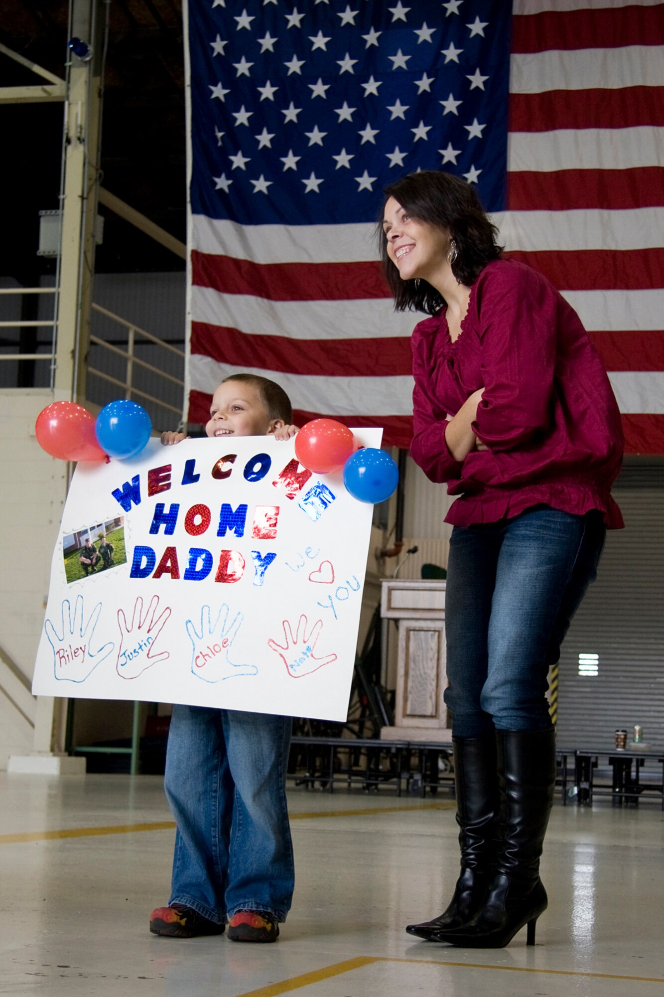 GRISSOM AIR RESERVE BASE, Ind. -- Rebecca Walls and her son Nate, 5, stand in a hangar here as they wait for Tech. Sgt. Ryan Walls to deplane a KC-135R Stratotanker after returning from a recent deployment. Sergeant Walls, an avionics guidance control specialist with the 434th Aircraft Maintenance Squadron, returned to Grissom recently with other deployed Airmen. (U. S. Air Force photo/Tech. Sgt. Mark R. W. Orders-Woempner)