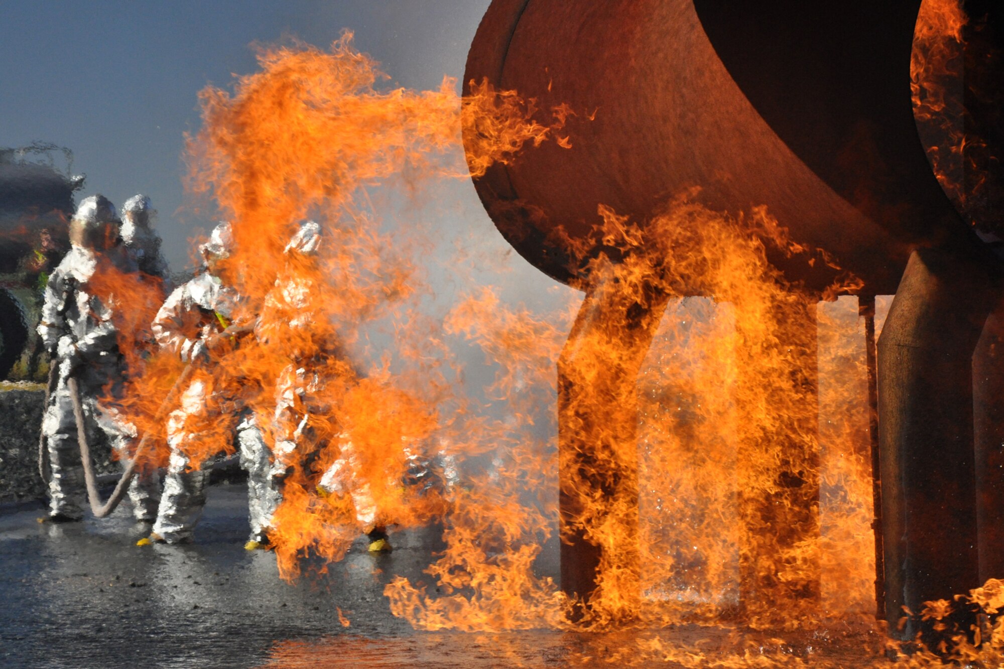 Firefighters with the 917th Civil Engineer Squadron attack a fire outside a large frame aircraft trainer during annual wartime training at Barksdale Air Force Base, La., Nov. 5, 2010. Approximately 20 members of the 917 CES were involved in this phase, which included extinguishing fires on both the outside and inside of the aircraft trainer. It was a part of their annual Air Force Certification process for Airport Rescue Firefighting.  (U.S. Air Force photo/Tech. Sgt. Jeff Walston) 