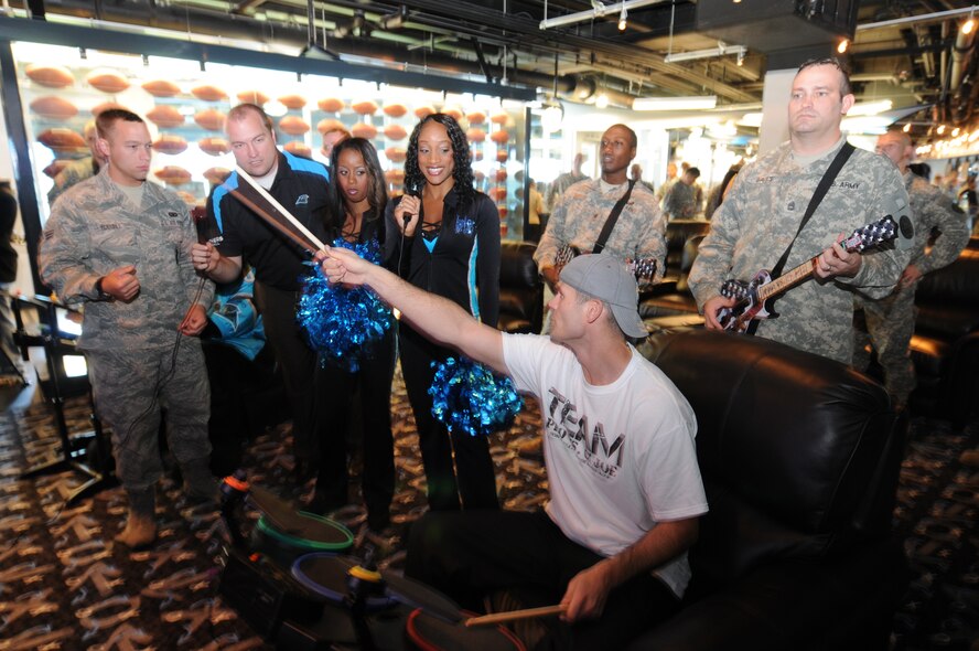 Charlotte, N.C. Greg Zinone, founder of Pros vs GI Joe takes the drums for a game of Rock Band during the Pros Vs G.I. Joe event at the Bank of America Stadium. Pros vs.GI Joe is a nonprofit organization that sets up real-time vide game competitions between professional athletes and celebrities and troops around the world, in-person and via online gaming. NCNG Photo by Tech. Sgt. Brian E. Christiansen.