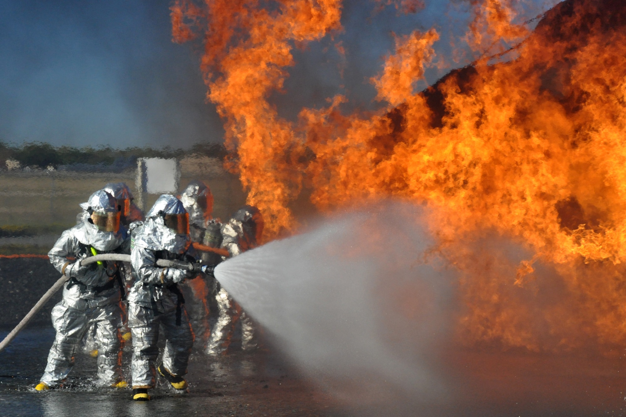Firefighters with the 917th Civil Engineer Squadron attack a fire outside a large frame aircraft trainer during annual wartime training at Barksdale Air Force Base, La., Nov. 5, 2010. Approximately 20 members of the 917 CES were involved in this phase, which included extinguishing fires on both the outside and inside of the aircraft trainer. It was a part of their annual Air Force Certification process for Airport Rescue Firefighting.  (U.S. Air Force photo/Tech. Sgt. Jeff Walston) 