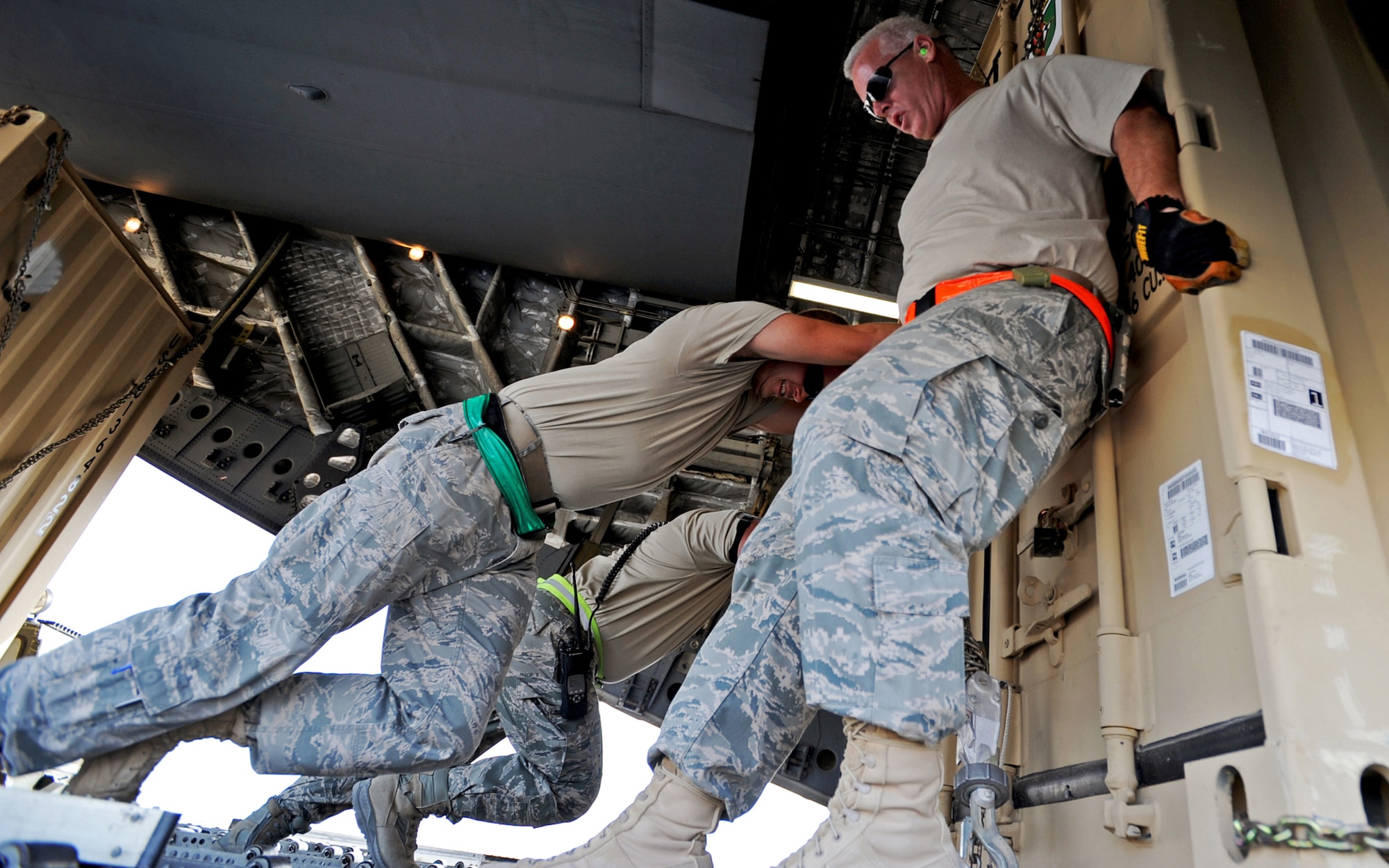 SOUTHWEST ASIA - Airmen from the 386th Expeditionary Logistics Readiness Squadron Aerial Port use muscle power to push a pallet of cargo onto a C-17 Globemaster III at an undisclosed air base here Nov. 3, 2010. Known informally as "Port Dogs," Aerial port Airmen inspect and palletize all cargo before shipment, from food and water to ammunition and rolling stock. They also work closely with aircraft loadmasters to carefully position the cargo inside aircraft, loading it into planes with massive forklifts or special flat-bed trucks known as K-loaders. (U.S. Air Force photo by Senior Airman Laura Turner)