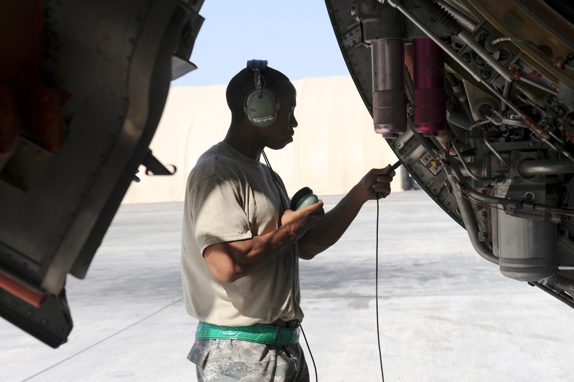 Staff Sgt. Cory Pucket, 380th Expeditionary Aircraft Maintenance Squadron KC-10 Extender propulsion technician, connects a headset to an engine interphone jack port during KC-10 engine troubleshooting Nov. 5, 2010 at an undisclosed location in Southwest Asia. (U.S. Air Force photo/Tech. Sgt. April Wickes) 