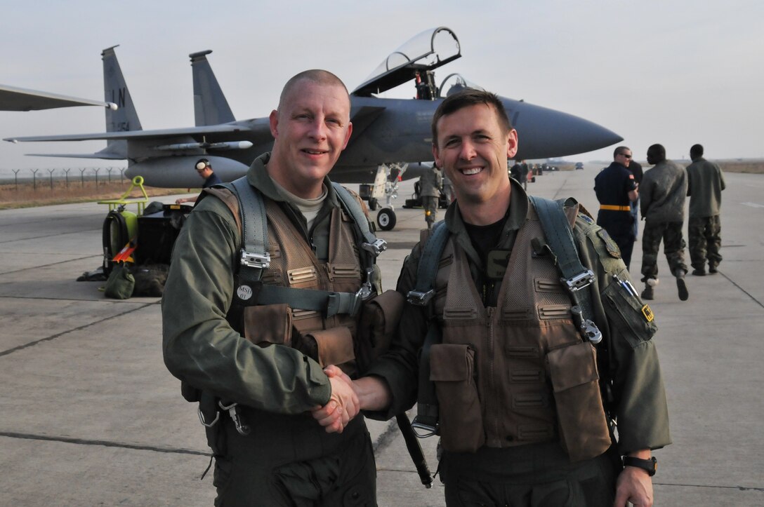 CAMPIA TURZII AIR BASE, Romania – Senior Master Sgt. Michael Seelhoff, 493rd Aircraft Maintenance Unit NCO in charge, shakes hands with Lt. Col. Skip Pribyl, 493rd Fighter Squadron commander, on the flightline here Nov. 2. Colonel Pribyl had just piloted the F-15C Eagle that carried Sergeant Seelhoff on the first incentive flight of his 25-year career. (U.S. Air Force photo/Senior Airman David Dobrydney)