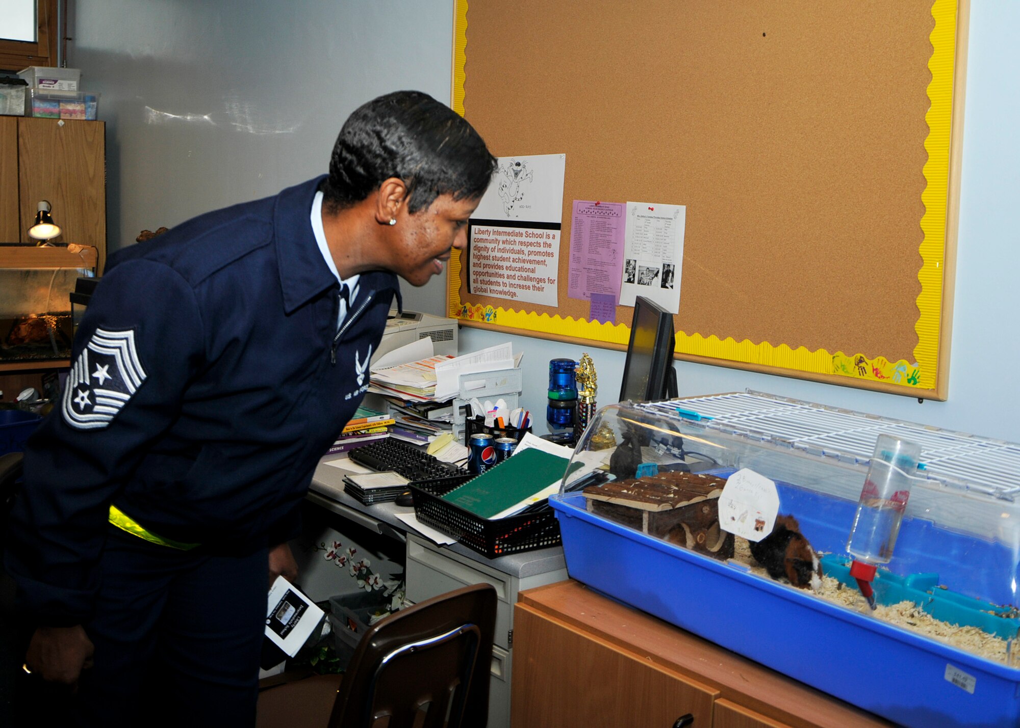 ROYAL AIR FORCE LAKENHEATH, England – 48th Fighter Wing Command Chief Master Sgt. SaRita Lathan looks at guinea pigs and rabbits in a classroom at the Lakenheath Intermediate School during a visit on Nov. 8. (U.S. Air Force photo/Airman 1st Class Tiffany M. Deuel)