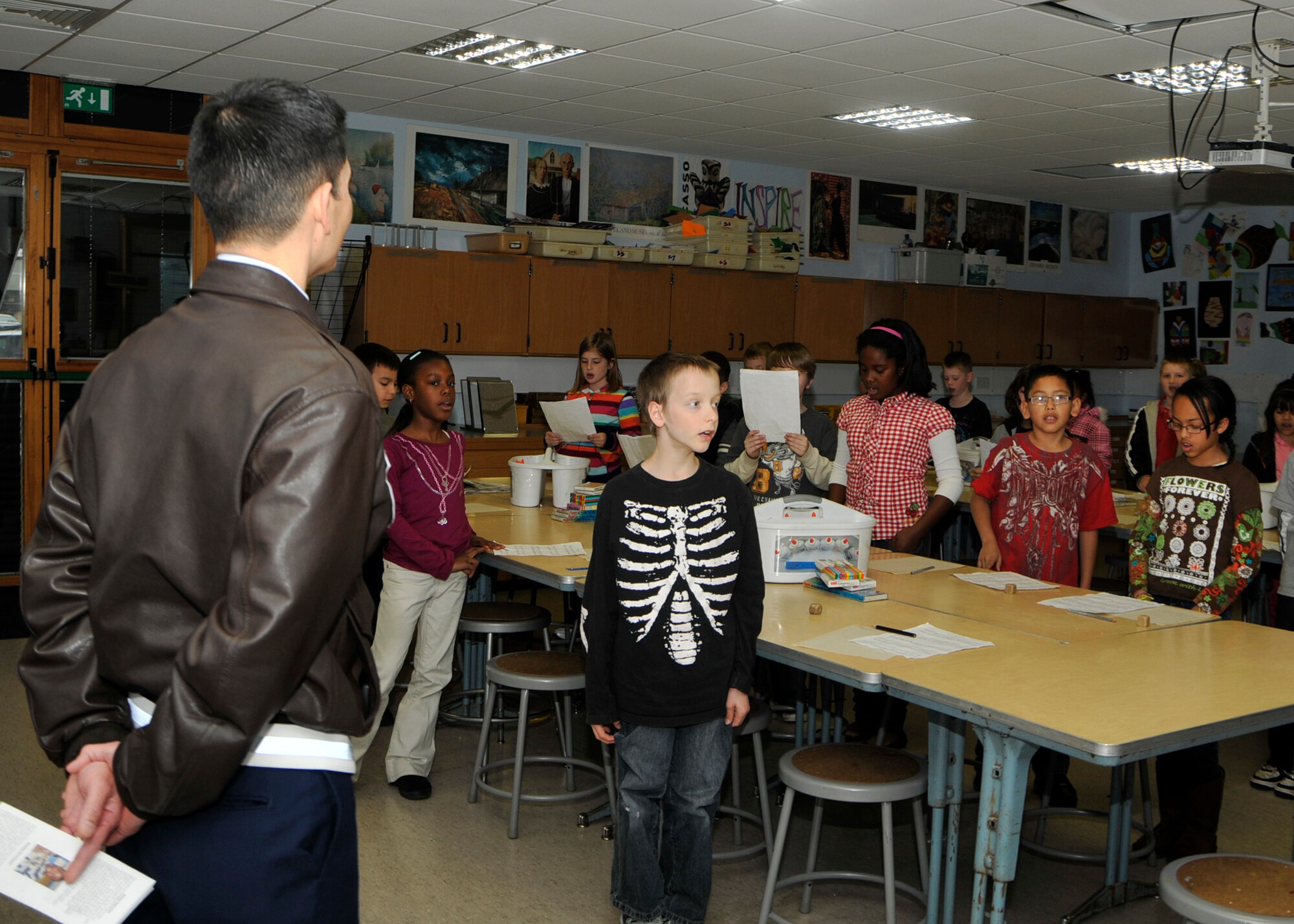 ROYAL AIR FORCE LAKENHEATH, England – 48th Fighter Wing Commander Col. John Quintas listens as Lakenheath Intermediate School students sing their school song during his visit on Nov. 8. (U.S. Air Force photo/Airman 1st Class Tiffany M. Deuel)