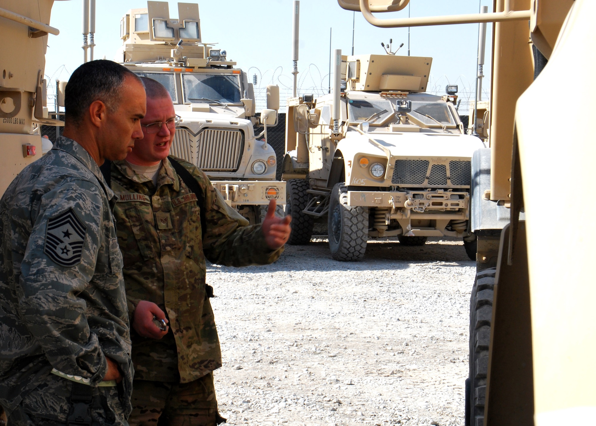 Staff Sgt. Andrew Phillips shows off some features of the mine-resistant, ambush-protected, all-terrain vehicle to Chief Master Sgt. Mark Villella during his visit to Kandahar Airfield, Afghanistan, Nov. 7. Sergeant Phillips is with the 807th Expeditionary Air Support Operations Squadron, and Chief Villella is the Air Force Central Command chief. (U.S. Air Force photo by Senior Airman Melissa B. White/Released)