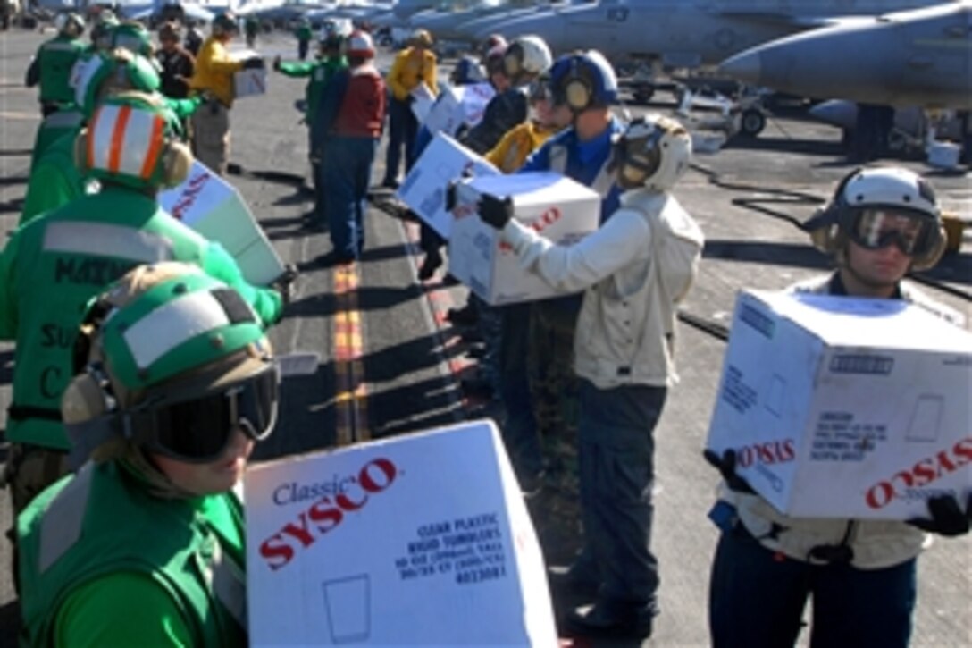 U.S. Navy sailors take boxes off a C-2A Greyhound in the Pacific Ocean, Nov. 9, 2010, to assist the Carnival cruise ship C/V Splendor. The sailors are assigned to the aircraft carrier USS Ronald Reagan, which was diverted from its current training maneuvers to help deliver 4,500 pounds of supplies to the cruise ship.