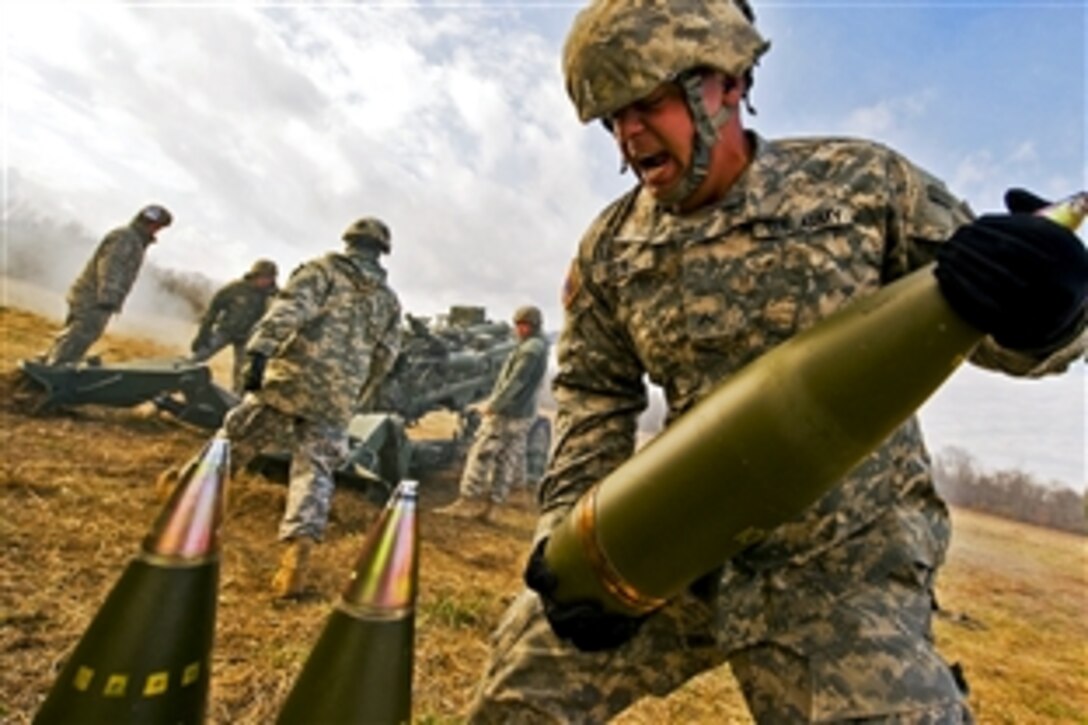 U.S. Army Pvt. Darrell Futrell lifts a 155mm round weighing about 100 pounds on Camp Atterbury Joint Maneuver Training Center in central Indiana, Nov. 4, 2010. Futrell and soldiers assigned to his Indiana National Guard unit fired the round from an M777 Howitzer, which was recently issued to the Indiana Guard.