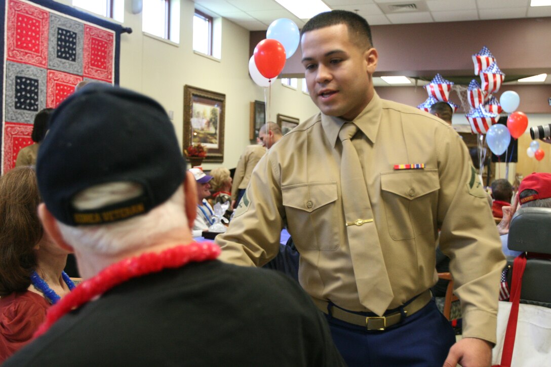 Lance Cpl. Juan Figueroa, a fiscal clerk with Marine Forces Reserve Headquarters shakes hands with a veteran at the Southeast Louisiana War Veteran’s home in Reserve, La. Twelve Marines from MarForRes visited the home on the Marine Corps birthday, also the day before Veteran’s day, to meet and greet various veterans.