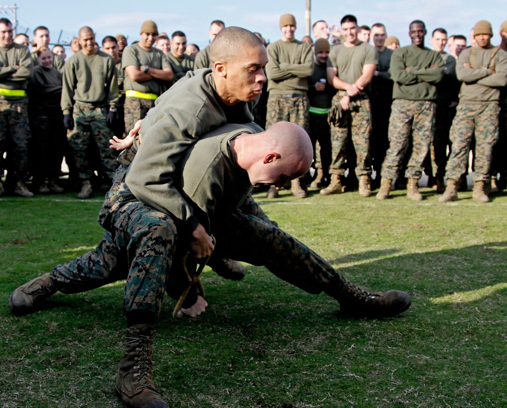 1st Lt. Harold Hamilton, Marine All-Weather Fighter Attack Squadron 242 intellegence officer, wrestles with Staff Sgt. Matthew Stuart, a VMFA(AW)-225 air framer, as part of the own-the-bone competition during the annual Marine Aircraft Group 12 field meet at the Penny Lake fields here Nov. 10. During the own-the-bone competition, two competitors, each representing his unit, would hold onto the handles of a bow shaped iron and try to wrestle it free from his opponent’s hand with one hand secured behind his back.