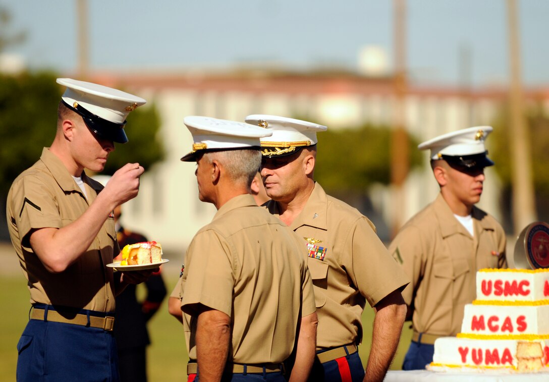 Pfc. Conor Bradwell-Johnson, the station's youngest Marine, takes a bite of birthday cake before passing it to Lt. Col. Charles Carroll, the oldest Marine at the Marine Corps Air Station in Yuma, Ariz. on Nov. 10, 2010 in celebration of the Corp's 235th birthday.