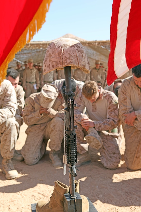 Marines with 2nd Battalion, 9th Marine Regiment, pay their respect in front of a battlefield cross display honoring Lance Cpl. Terry E. Honeycutt Jr., a machine-gunner with Fox Company, 2/9, during a memorial service at a Marine Corps Base in Helmand Province, Afghanistan, Nov. 11. Honeycutt gave the ultimate sacrifice, Oct. 27, while conducting combat operations in Northern Marjah.