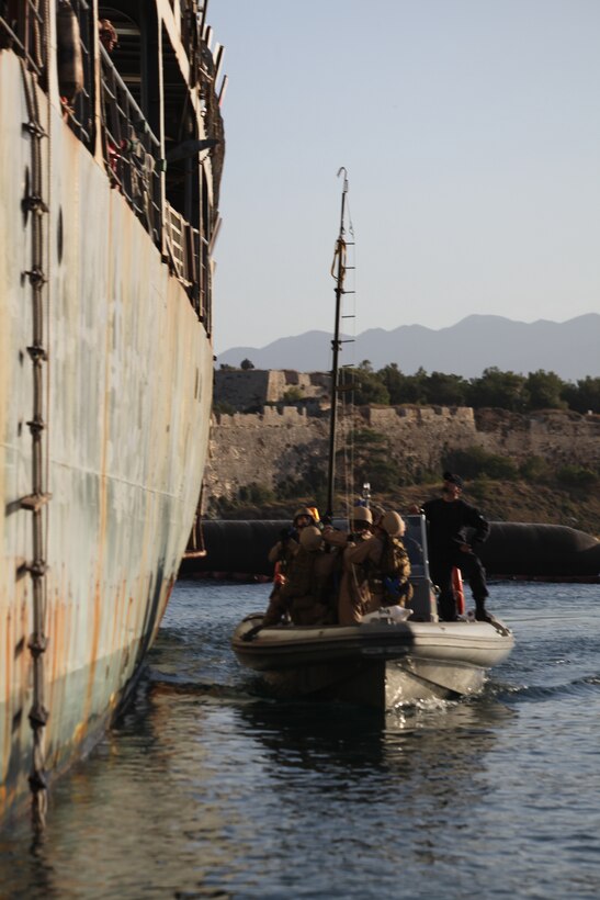 Marines with the 26th Marine Expeditionary Unit's Maritime Interception Operations (MIO) assault force raise a telescopic pole to attach a cave ladder to HNS Aris during bottom up training at Souda Bay, Crete, Greece, Nov. 11, 2010. The MIO assault force went through a one-week course at the NATO Maritime Interception Operations Training Center in tactics to board a suspect vessel.