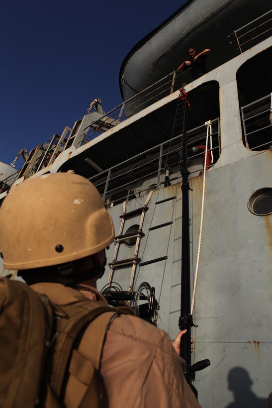 A Marine with the 26th Marine Expeditionary Unit's Maritime Interception Operations (MIO) assault force attaches a cave ladder to HNS Aris using a telescopic pole during bottom up training at Souda Bay, Crete, Greece, Nov. 11, 2010. The MIO assault force went through a one-week course at the NATO Maritime Interception Operations Training Center in tactics to board a suspect vessel.