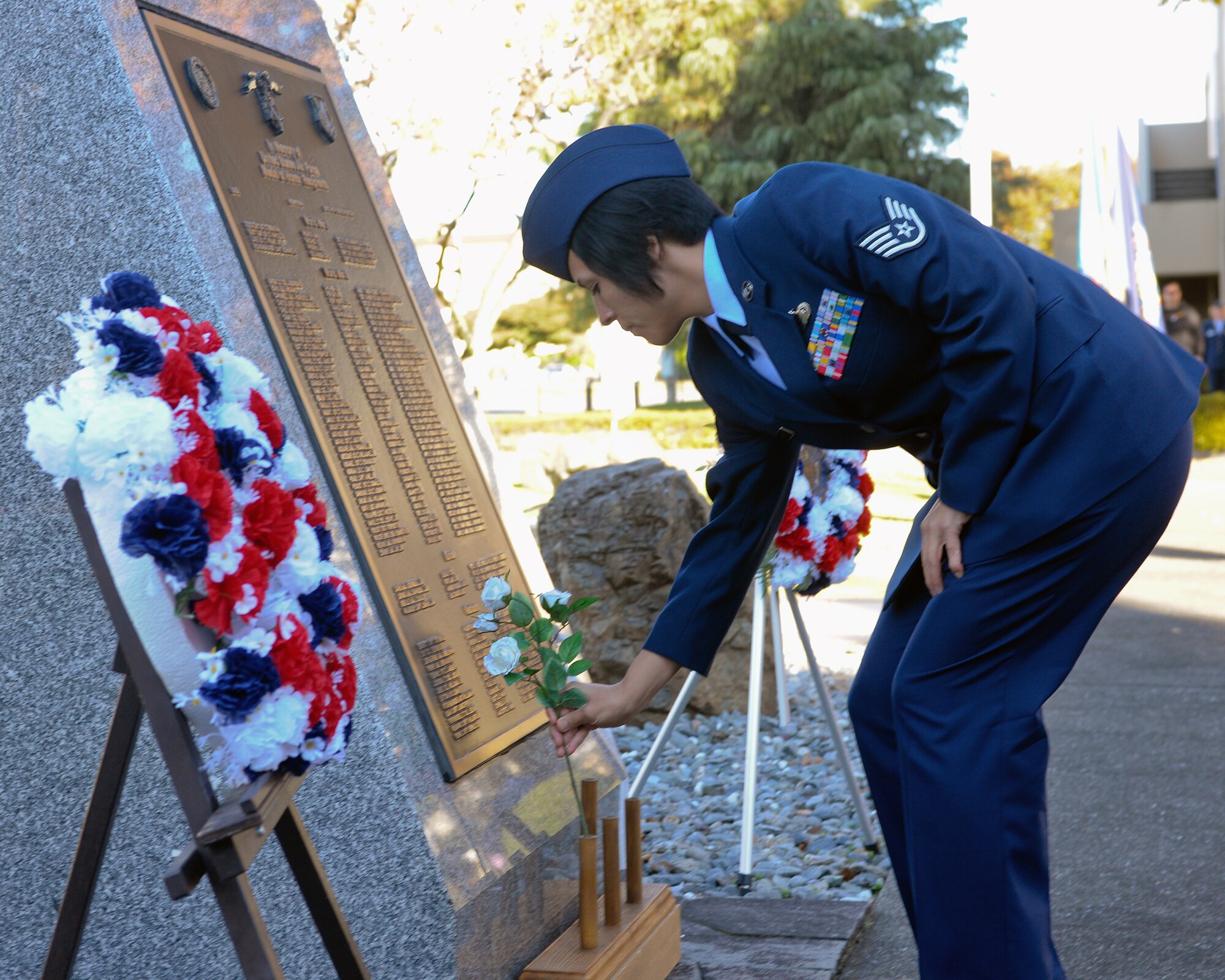 YOKOTA AIR BASE, Japan -- Staff Sgt. Sonora Vasquez, 374th Force Support Squadron, presents a flower to the monument here Nov. 11 during the Veterans Day ceremony. Men and Women from the Yokota attended this ceremony to remember the contributions made to our nation by service members-past and present. (U.S. Air Force photo/Osakabe Yasuo)
