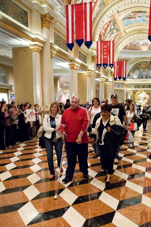 LAS VEGAS --A wounded combat veteran and his family walk down the hall of The Venetian on Veteran's Day, Nov. 11, 2010, to begin their all expenses paid vacation weekend and are greeted by applause, cheering, and encouraging signs. This weekend getaway was planned by ThanksUSA, an organization created in an effort to thank the men and women of our armed forces and their families for their service to the country with scholarship programs and events like the "Tribute to the Troops." (U.S. Air Force Photo / Airman 1st Class Jamie Nicley)(Released)